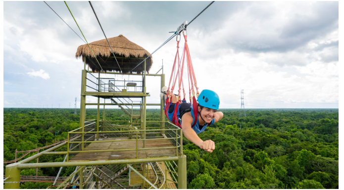 A zipliner captured mid-flight, enjoying the rush and scenery of Cancun.