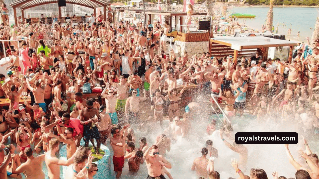 Sunset beach party with music, lights, and people dancing