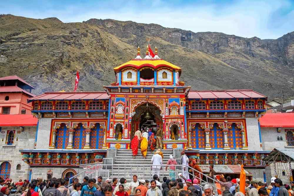 Badrinath Temple in Uttarakhand with devotees entering the colorful shrine set against the Himalayan mountains