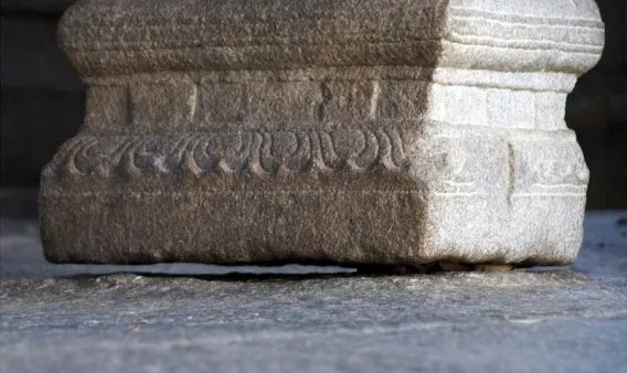 Close-up view of the famous hanging pillar at Lepakshi Temple, showing the small gap between the pillar base and the ground.