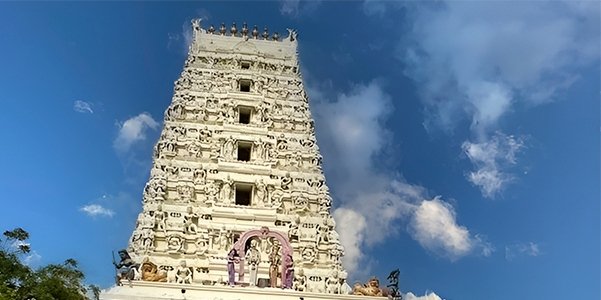 Sri Tirupatamma Ammavari Temple gopuram in Penuganchiprolu with intricate carvings against a blue sky