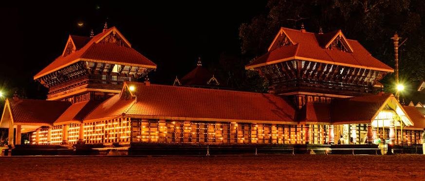 Guruvayur Temple illuminated at night with traditional Kerala architecture and glowing oil lamps