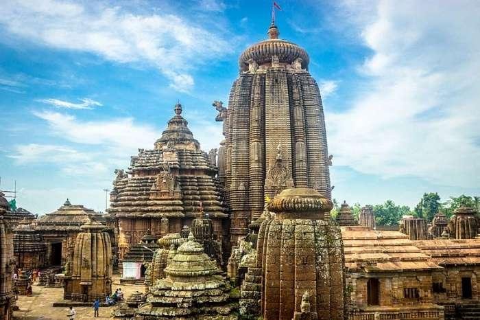 Ancient Lingaraj Temple in Bhubaneswar showcasing classic Kalinga-style architecture under a blue sky.