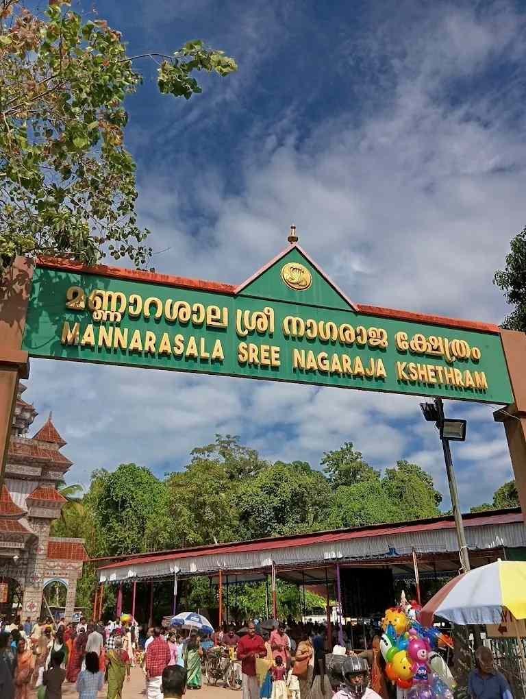 Entrance arch of Mannarasala Sree Nagaraja Temple in Kerala with devotees and traditional temple architecture