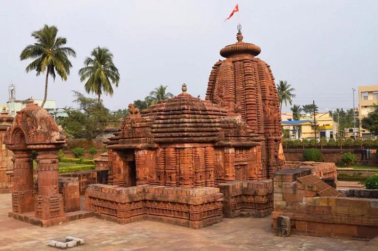 Side view of Mukteswara Temple Bhubaneswar featuring ancient red sandstone architecture and temple complex surroundings.
