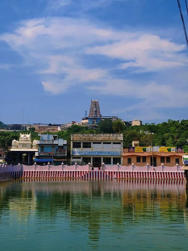 Scenic temple tank view with Thiruttani Murugan Temple hill in the background.