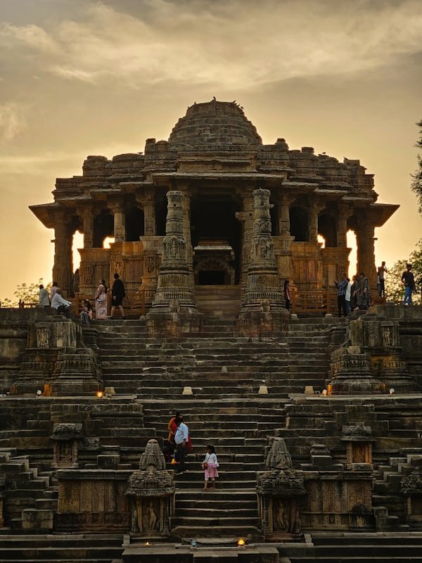 Front view of Konark Sun Temple in Odisha with grand stone steps and ancient carved pillars during sunset.