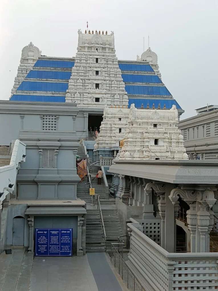 ISKCON Bangalore temple exterior view showcasing its majestic white gopuram and modern blue-glass architecture in Bengaluru.