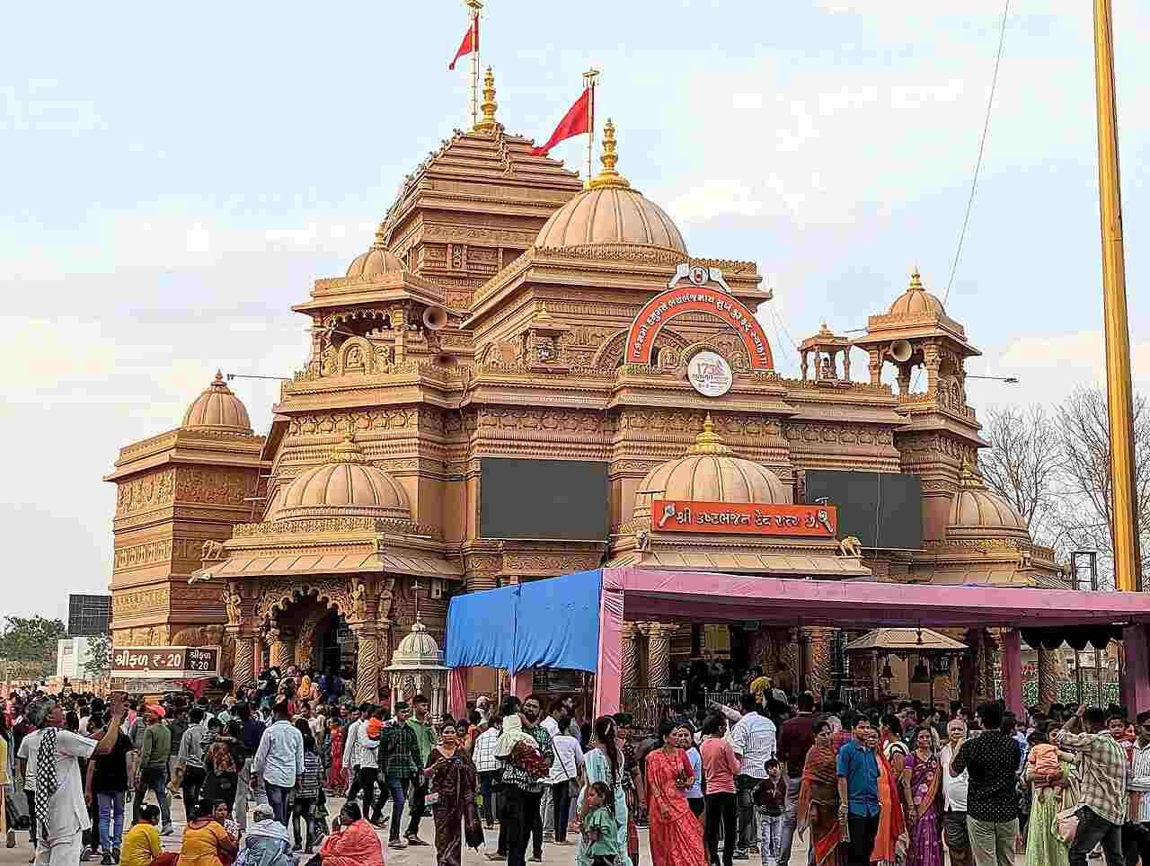 Grand entrance of Kashtabhanjan Dev Hanuman Temple in Salangpur filled with devotees during a spiritual gathering.
