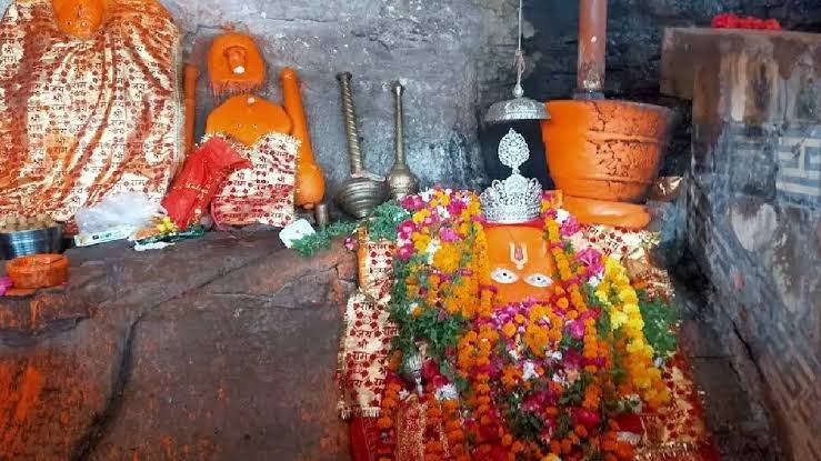 Hanuman Dhara Temple idol in Chitrakoot decorated with flowers and sindoor inside the sacred shrine.