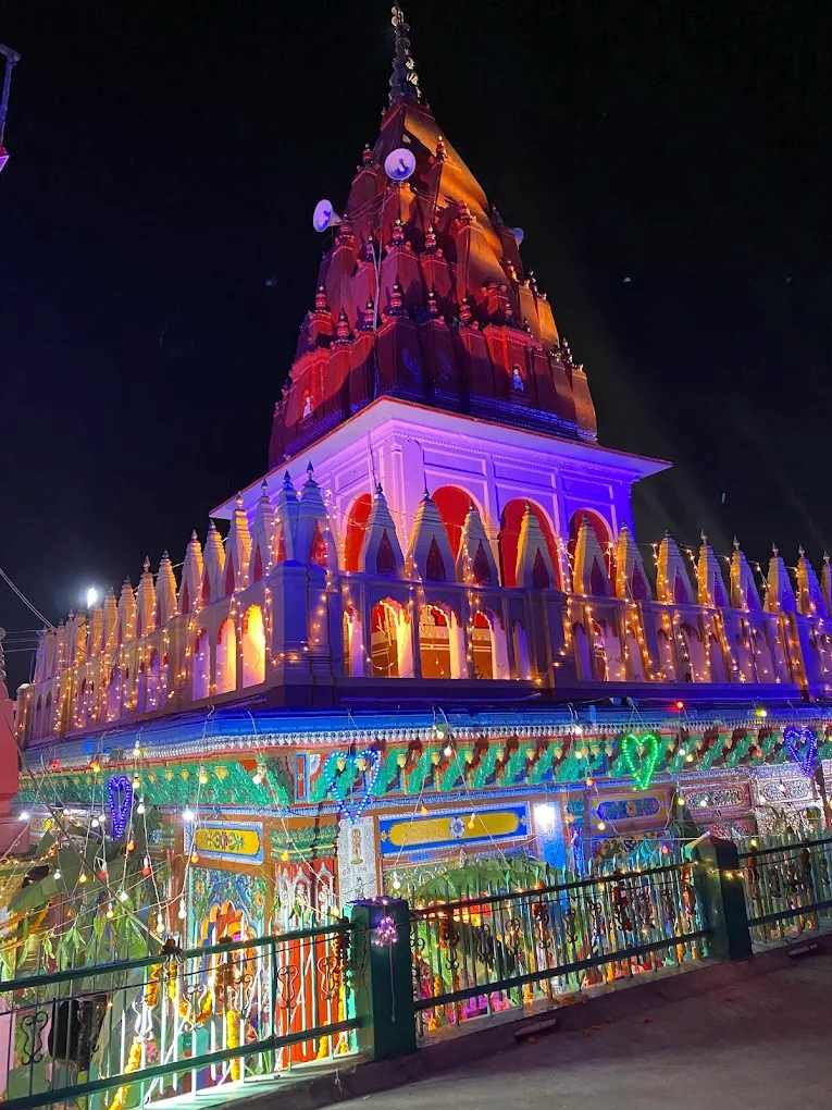Hanuman Garhi Temple in Ayodhya beautifully illuminated with colorful lights during a religious celebration at night.