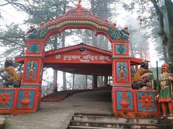Entrance gate of Jakhu Hanuman Temple surrounded by cedar trees in Shimla