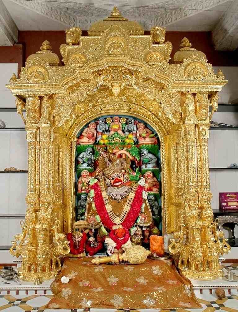 Kashtabhanjan Hanuman idol adorned with gold ornaments and flower garlands inside the sanctum of Salangpur Hanuman Temple, Gujarat.
