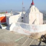 Yantrodharaka Hanuman Temple perched on a rocky hill in Hampi, Karnataka, overlooking the scenic Tungabhadra River valley.