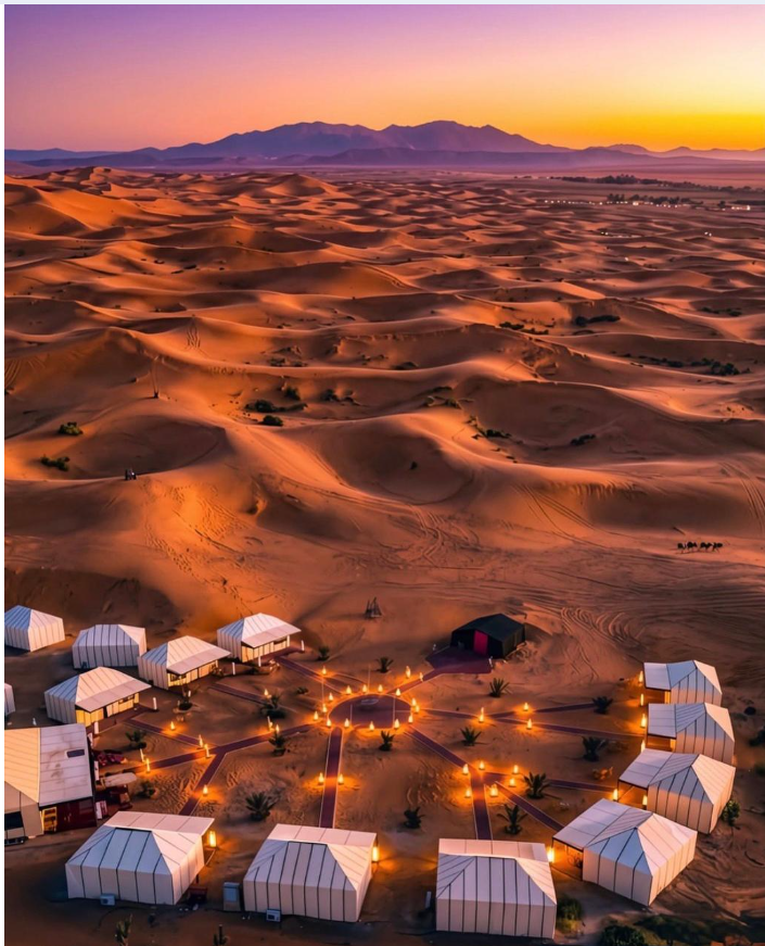 Luxury desert camp tents among the Erg Chebbi sand dunes in Merzouga, Morocco, offering a comfortable Sahara Desert camping experience.